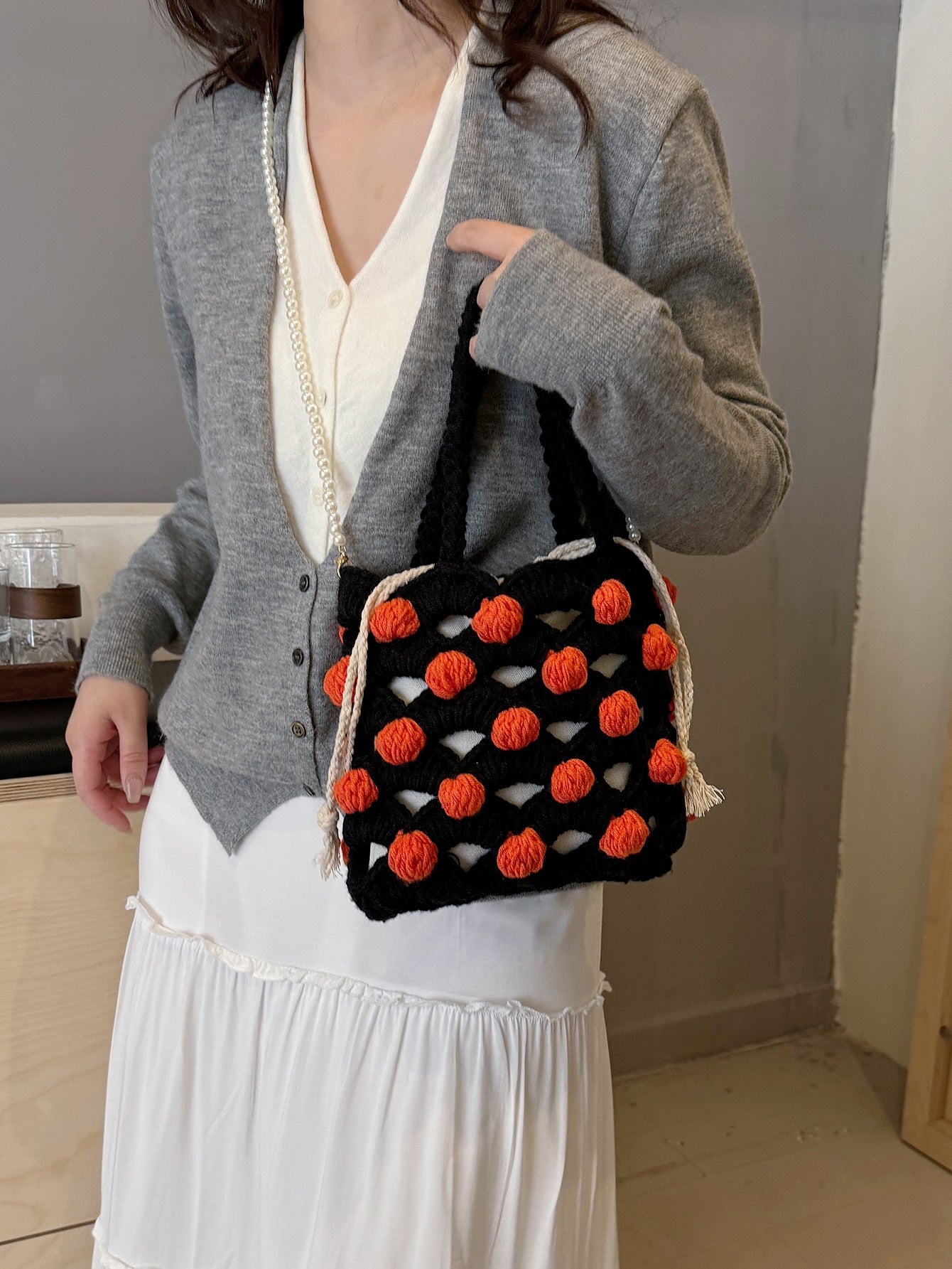 Black and orange handmade woven handbag with pearl decoration.