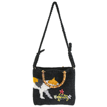 Handmade knitted black tote bag featuring a bamboo handle, embroidered cat design, and colorful floral accents. Lightweight and eco-friendly, perfect for casual or creative fashion styles.