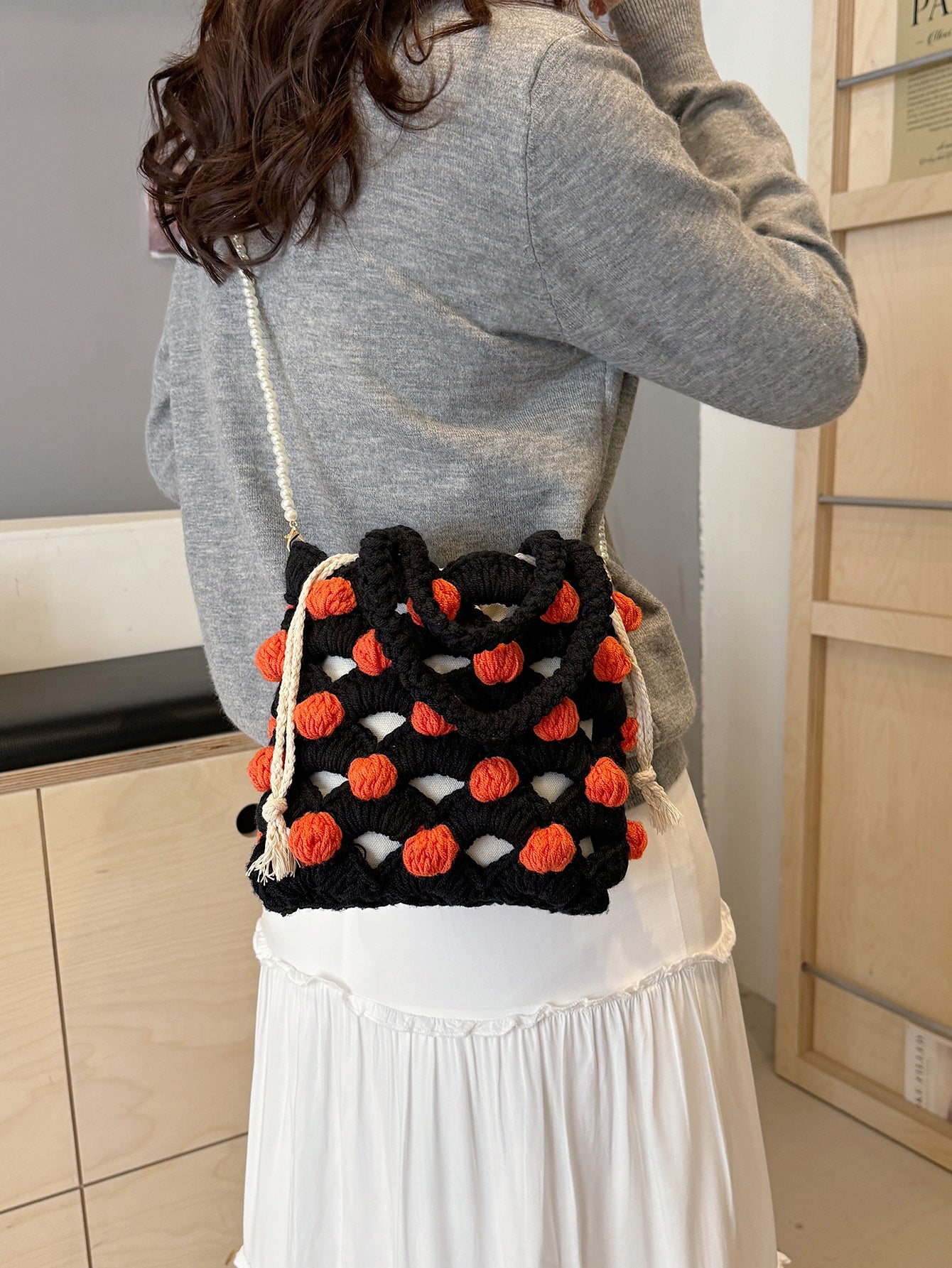 Black and orange handmade woven handbag with pearl decoration.

