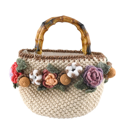Handwoven cotton tote bag with bamboo handles, decorated with crochet flowers in pink, coral, purple and white cotton blooms, natural beige base
