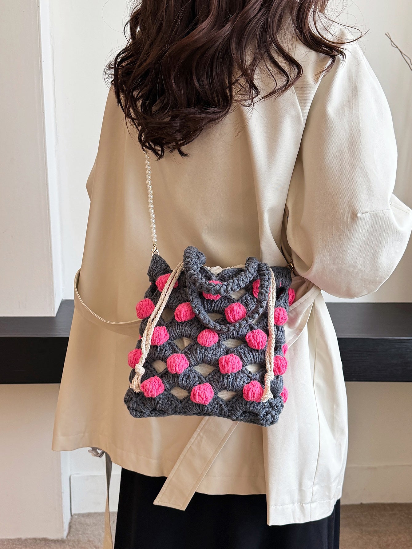 Handwoven tote bag with a gray woven base and pink circular accents, adorned with pearl chain details. Unique design, perfect for daily use or shopping.