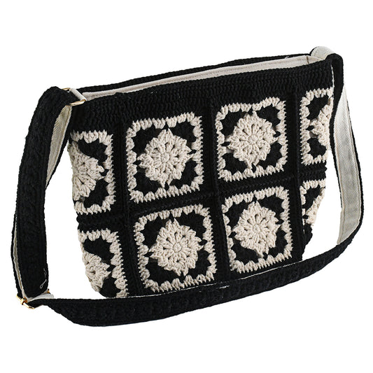 Handmade crochet crossbody bag with a black and white patchwork design, featuring square floral patterns, an adjustable strap, and a soft, lightweight texture.