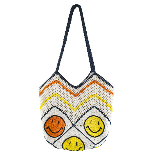 Handmade crochet tote bag with a white base, colorful chevron pattern, and three smiley face designs in orange, yellow, and navy. Features a soft navy strap and a spacious interior, perfect for casual outings or travel.