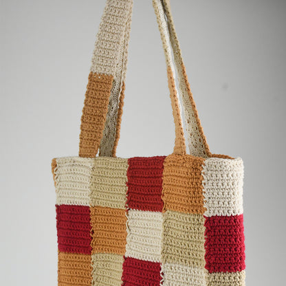 Handcrafted crochet tote bag with a checkered pattern in warm tones of red, beige, orange, and cream. Lightweight, durable, and spacious, perfect for daily use or shopping trips.