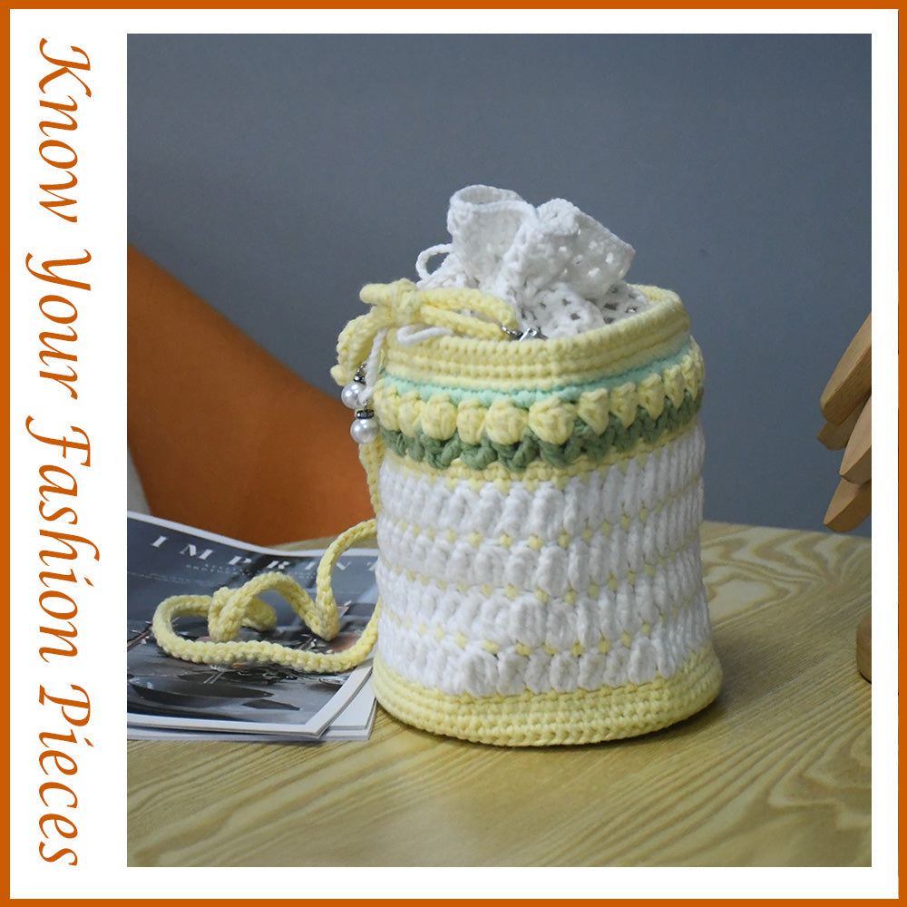 Handmade crochet bucket bag in white and yellow with pearl details, drawstring closure and adjustable shoulder strap
