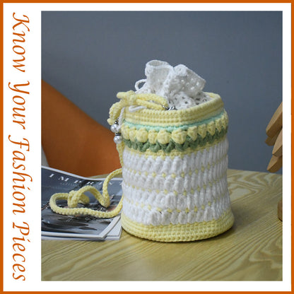 Handmade crochet bucket bag in white and yellow with pearl details, drawstring closure and adjustable shoulder strap
