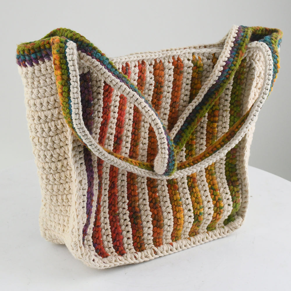 Handmade crochet tote bag featuring a natural cream base with colorful rainbow stripes. The bag has a spacious design with matching rainbow-accented shoulder straps, perfect for casual outings, shopping, or beach trips