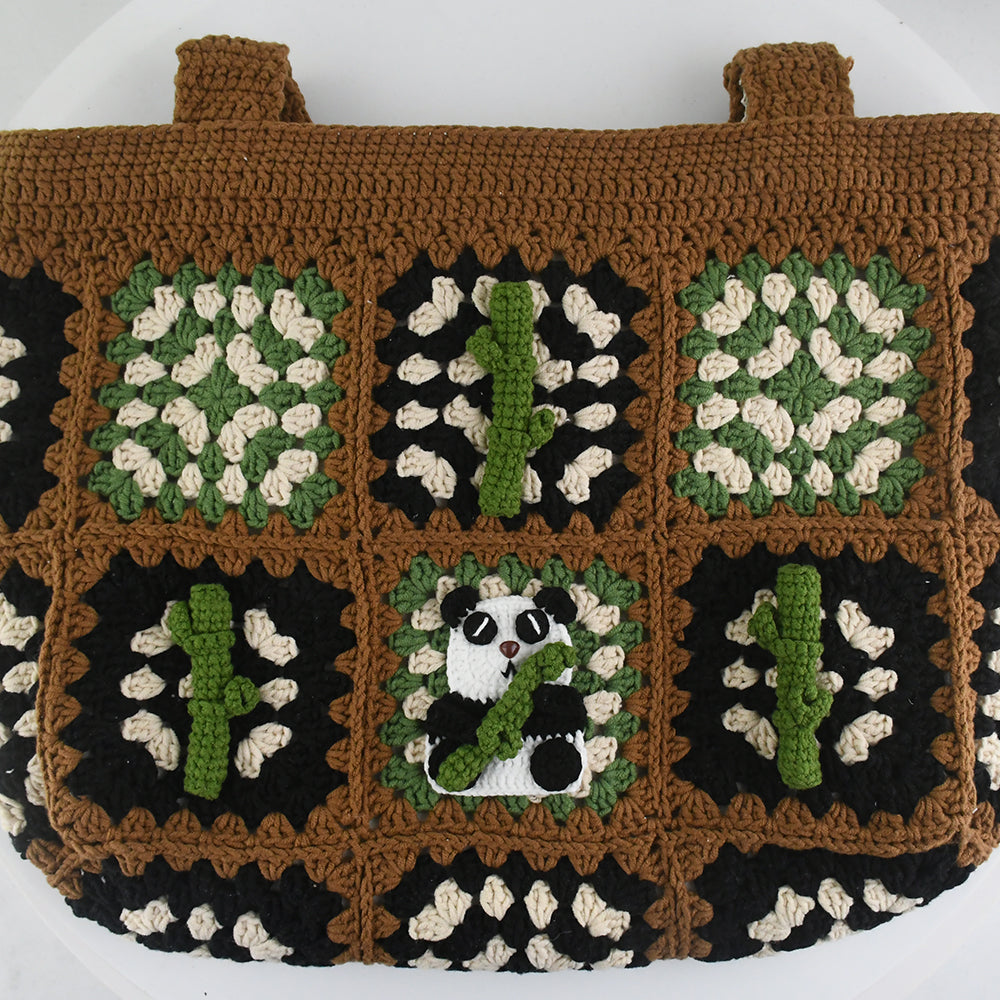 Handmade crochet patchwork bag with a brown base, black, green, and white patterns, featuring a panda and bamboo design in the center. Vintage style, eco-friendly, and lightweight, ideal for shopping or daily use.