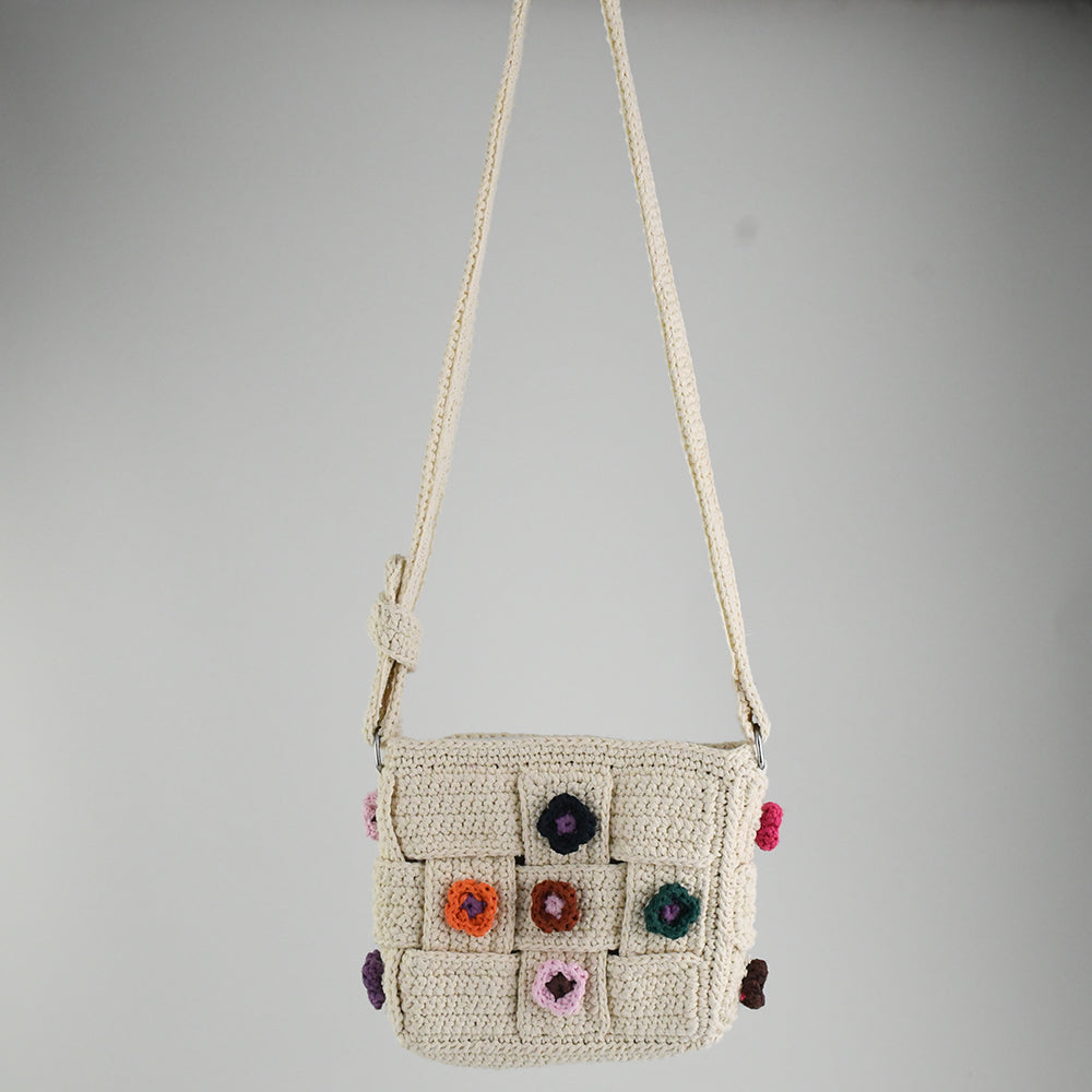 Handmade crochet shoulder bag with beige base and colorful floral accents, featuring a woven adjustable strap and a unique patchwork design. Lightweight and perfect for casual outings or daily use.