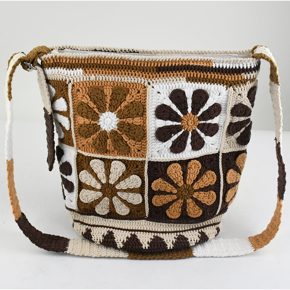 Handmade crochet shoulder bag with retro floral square patterns in earthy tones of brown, beige, and white. Features a long adjustable strap and a spacious bucket-style design, perfect for casual outings or shopping.