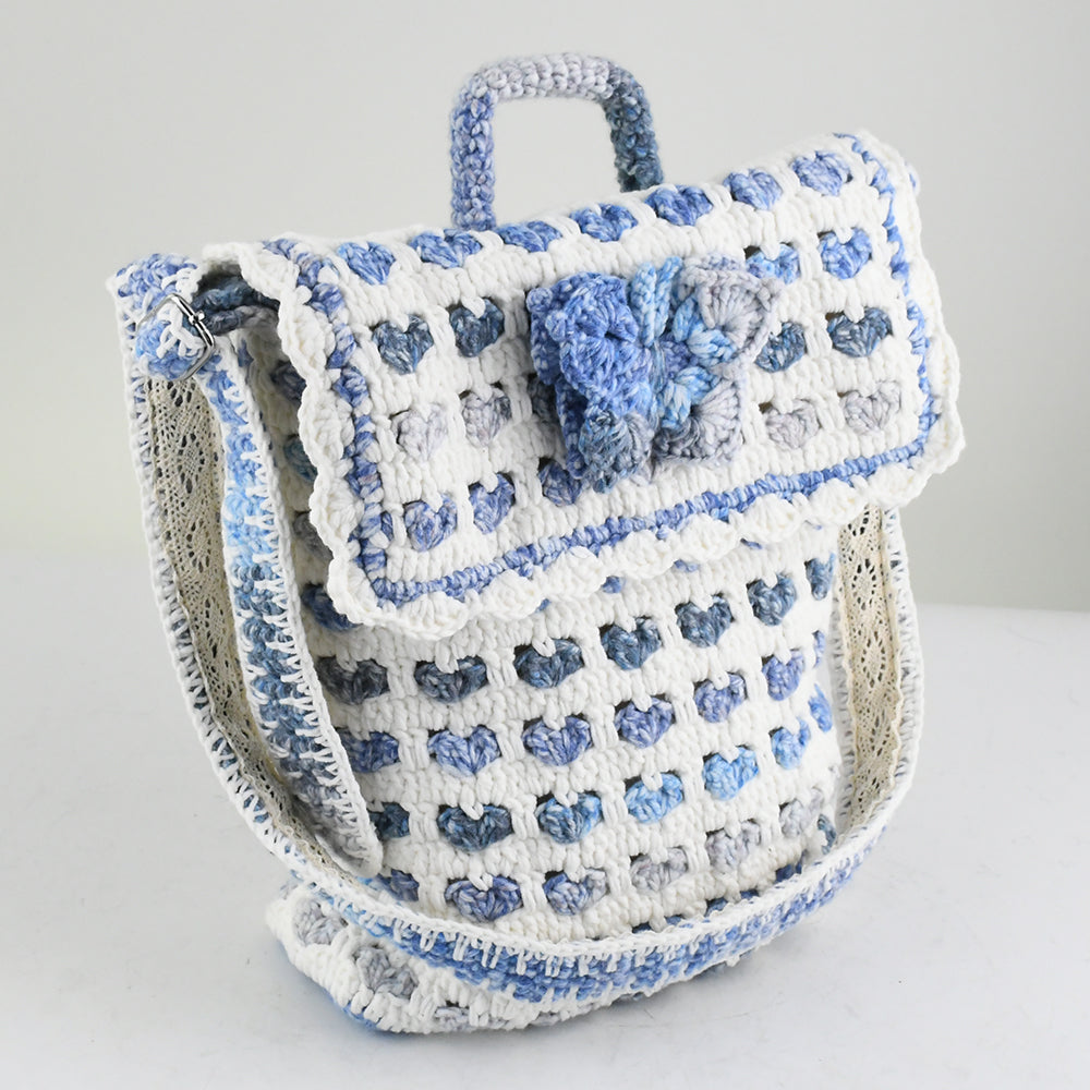 Handmade crochet shoulder bag with a unique blue and white floral pattern, featuring an adjustable strap and secure flap closure. Lightweight and perfect for everyday use.