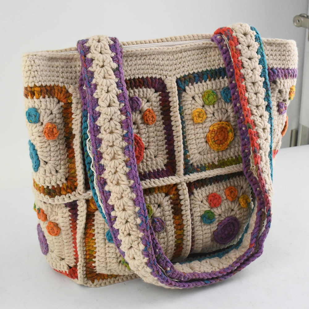 Handmade crochet tote bag with colorful floral and paw patterns, featuring a beige base and multicolor woven straps. Lightweight and spacious, perfect for casual outings or daily use.