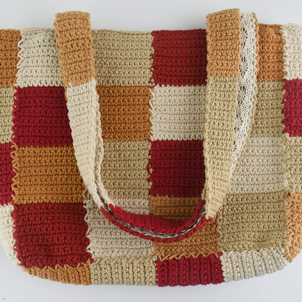 Handcrafted crochet tote bag with a checkered pattern in warm tones of red, beige, orange, and cream. Lightweight, durable, and spacious, perfect for daily use or shopping trips.