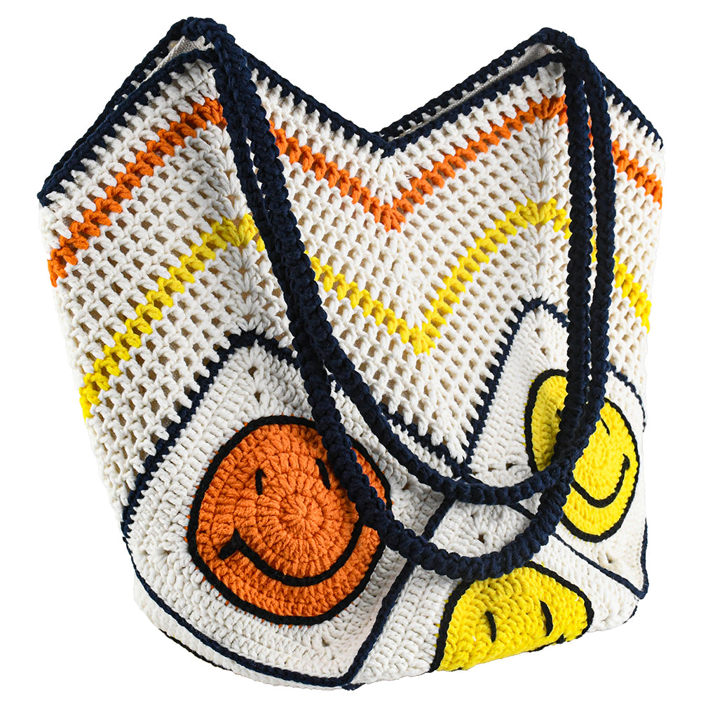 Handmade crochet tote bag with a white base, colorful chevron pattern, and three smiley face designs in orange, yellow, and navy. Features a soft navy strap and a spacious interior, perfect for casual outings or travel.