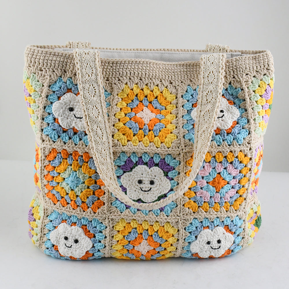 Handmade crochet tote bag with smiling cloud motifs and colorful patchwork squares in beige, yellow, blue, orange, and purple. Lightweight, eco-friendly, and spacious design, perfect for daily use or casual outings.