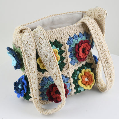 Handmade crochet tote bag featuring a colorful 3D floral design. Beige base with red, blue, green, and yellow flower accents. Lightweight, spacious, and perfect for shopping or casual outings.