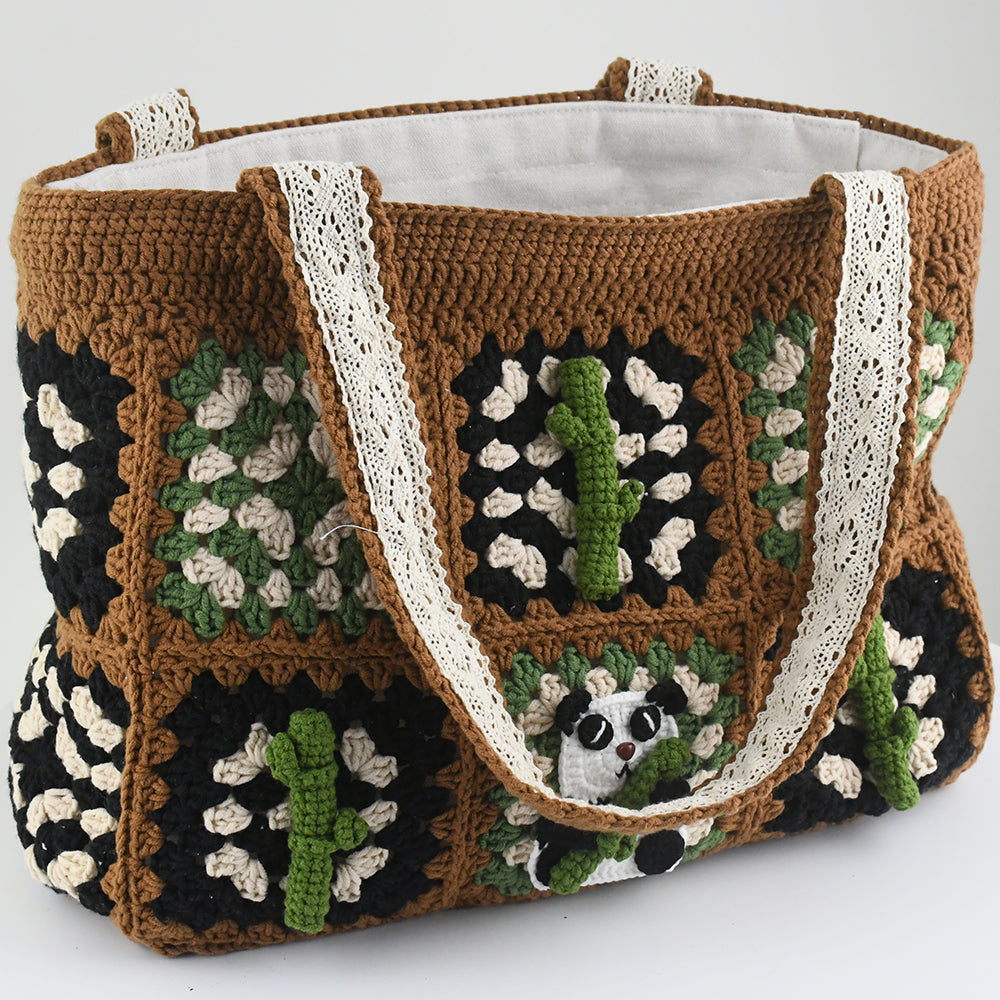 Handmade crochet patchwork bag with a brown base, black, green, and white patterns, featuring a panda and bamboo design in the center. Vintage style, eco-friendly, and lightweight, ideal for shopping or daily use.