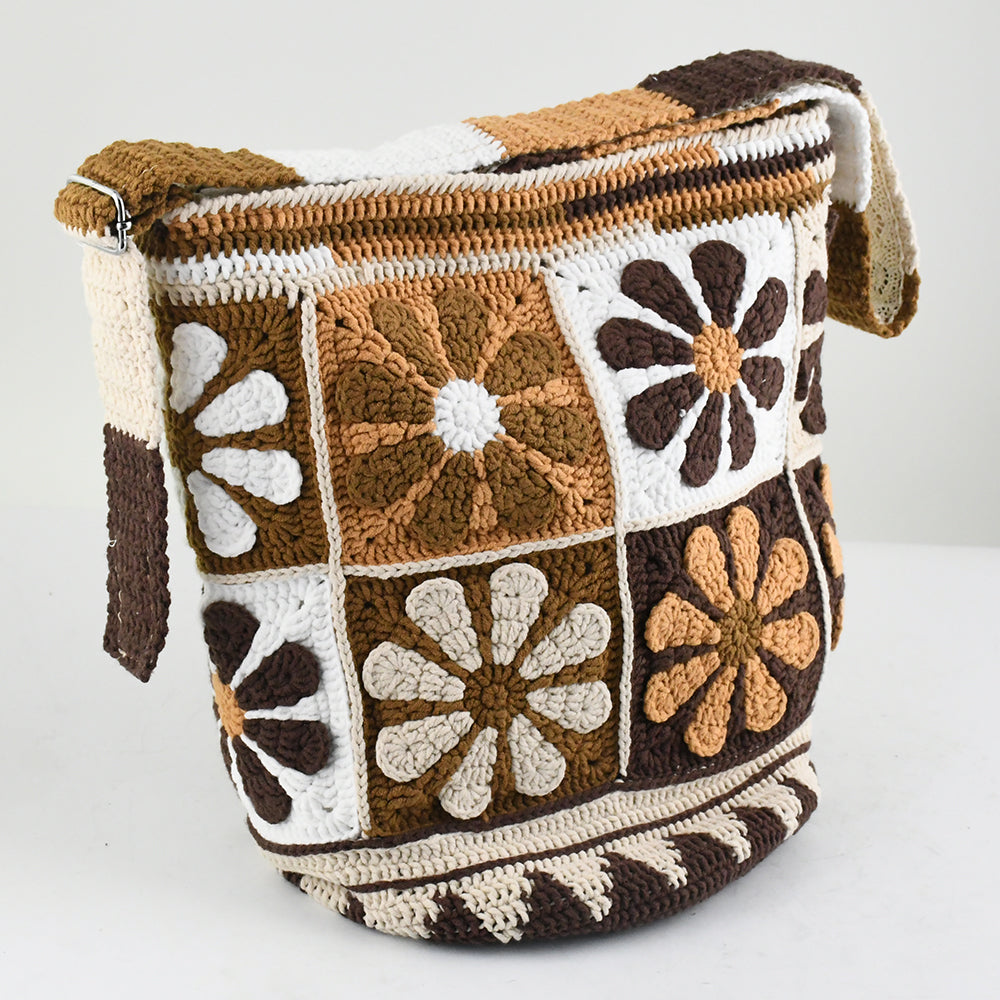 Handmade crochet shoulder bag with retro floral square patterns in earthy tones of brown, beige, and white. Features a long adjustable strap and a spacious bucket-style design, perfect for casual outings or shopping.