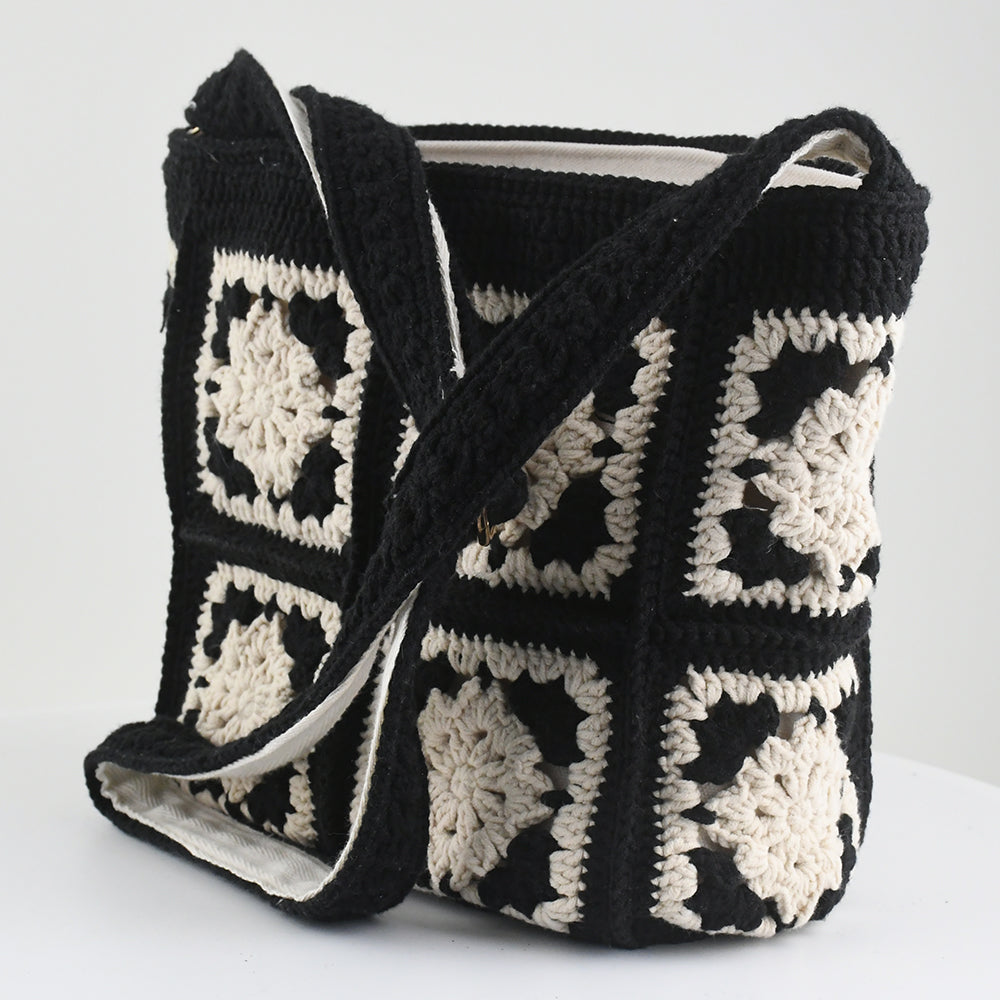 Handmade crochet crossbody bag with a black and white patchwork design, featuring square floral patterns, an adjustable strap, and a soft, lightweight texture.