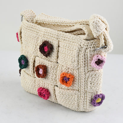 Handmade crochet shoulder bag with beige base and colorful floral accents, featuring a woven adjustable strap and a unique patchwork design. Lightweight and perfect for casual outings or daily use.