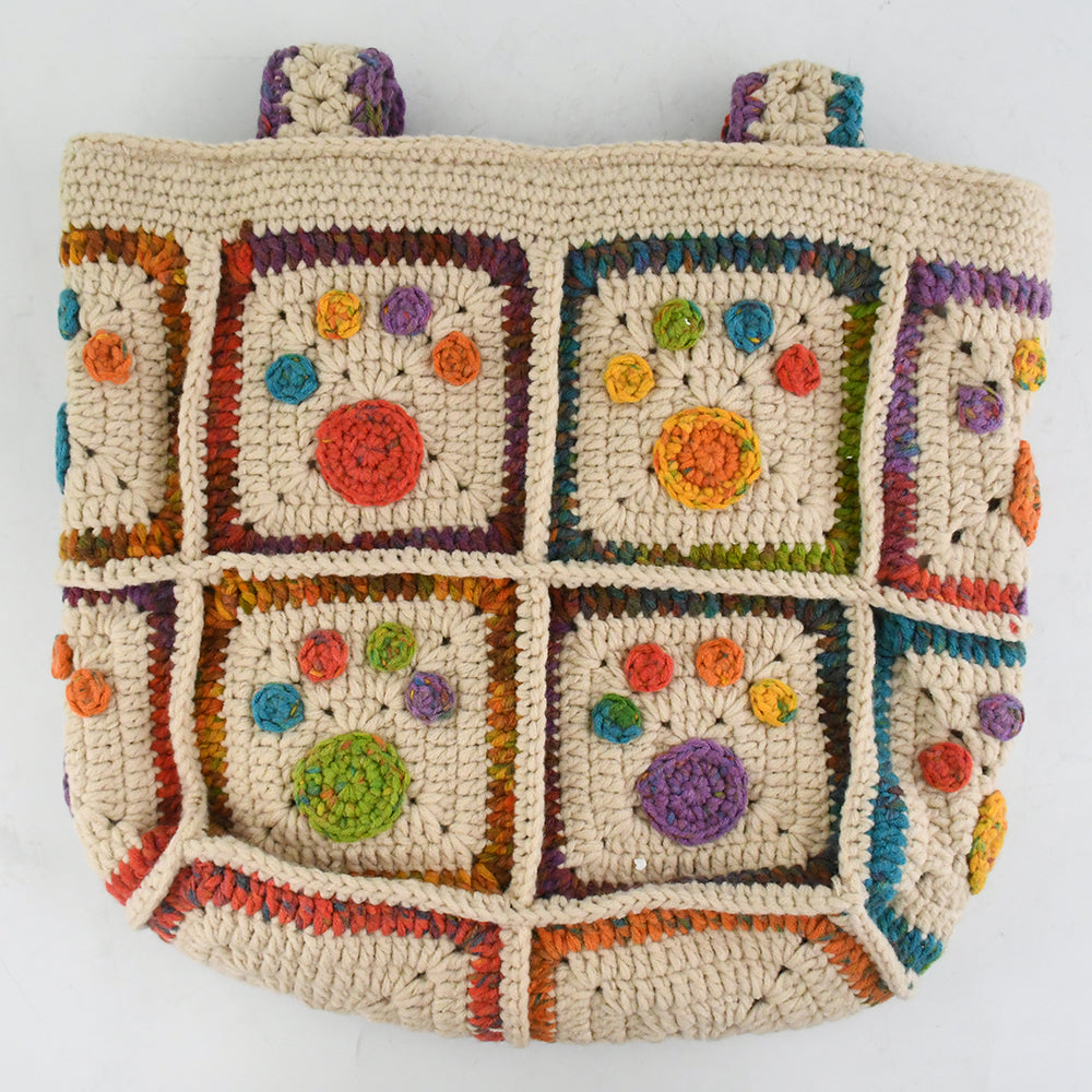 Handmade crochet tote bag with colorful floral and paw patterns, featuring a beige base and multicolor woven straps. Lightweight and spacious, perfect for casual outings or daily use.