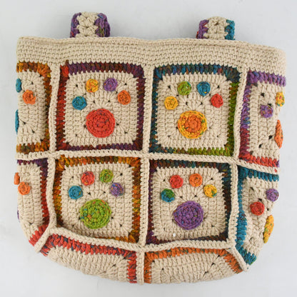 Handmade crochet tote bag with colorful floral and paw patterns, featuring a beige base and multicolor woven straps. Lightweight and spacious, perfect for casual outings or daily use.