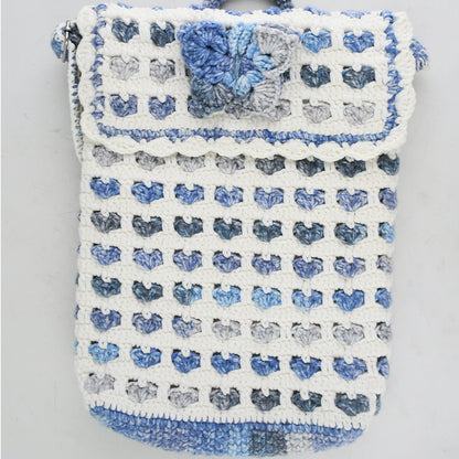 Handmade crochet shoulder bag with a unique blue and white floral pattern, featuring an adjustable strap and secure flap closure. Lightweight and perfect for everyday use.