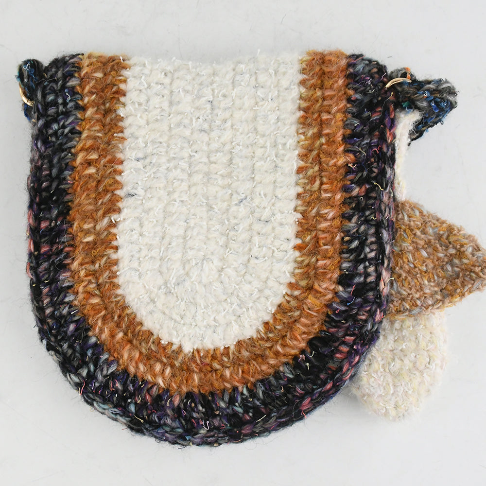 Handmade crochet crossbody bag with earthy tones, featuring a unique mushroom charm, semi-circle flap design, and durable woven strap. Lightweight and eco-friendly, perfect for boho and vintage-inspired styles.