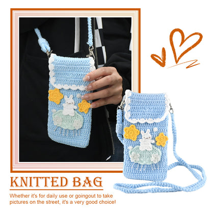 Handmade crochet phone crossbody bag in baby blue with white bunny on mint cloud applique and yellow stars, featuring scalloped white trim and braided strap
