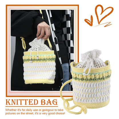 Handmade crochet bucket bag in white and yellow with pearl details, drawstring closure and adjustable shoulder strap

