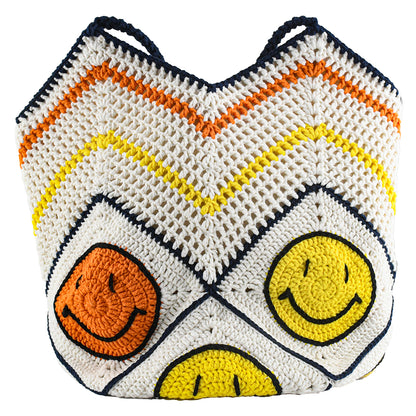 Handmade crochet tote bag with a white base, colorful chevron pattern, and three smiley face designs in orange, yellow, and navy. Features a soft navy strap and a spacious interior, perfect for casual outings or travel.