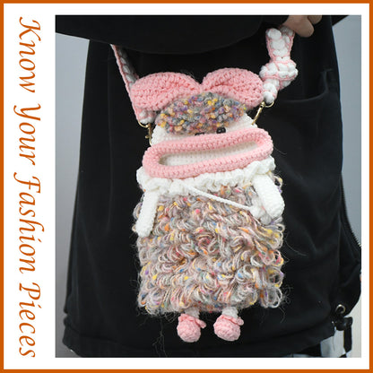 Handcrafted pink crochet doll crossbody phone pouch with zipper closure and cute facial details
