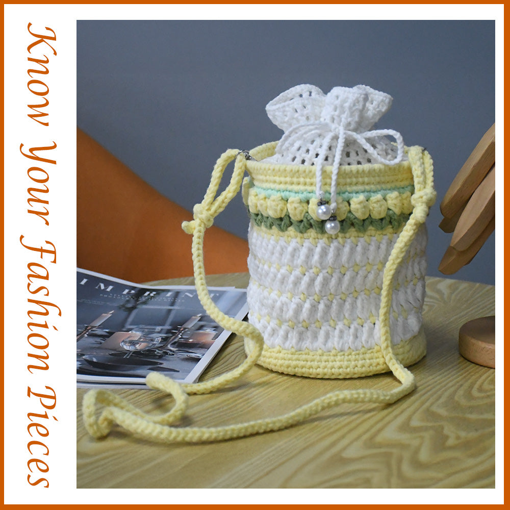 Handmade crochet bucket bag in white and yellow with pearl details, drawstring closure and adjustable shoulder strap
