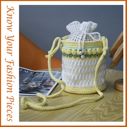 Handmade crochet bucket bag in white and yellow with pearl details, drawstring closure and adjustable shoulder strap
